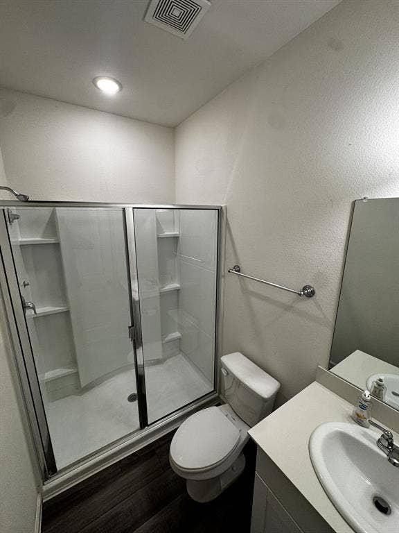 1813 Chapel Hill Road, Princeton, TX 75407 Shower with clear glass enclosure, white vanity with integrated sink, and dark wood-finish flooring