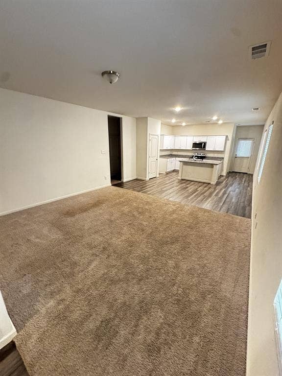 1813 Chapel Hill Road, Princeton, TX 75407 Open-concept living space featuring wood-finish flooring, recessed lighting, and a kitchen with white cabinetry and a central island
