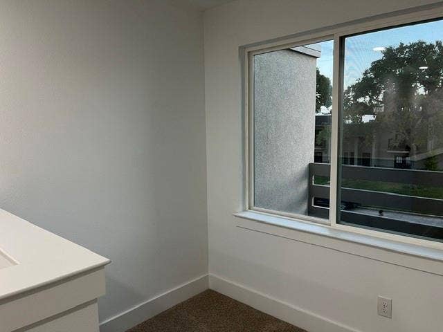 9473 Timberleaf Drive, Dallas, TX 75243 White interior walls, white window trim, dual-pane window, carpeted flooring, and a white electrical outlet