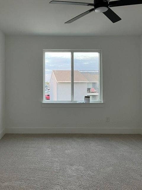9473 Timberleaf Drive, Dallas, TX 75243 Expansive room with neutral carpeting, a large window, and a ceiling fan with integrated lighting