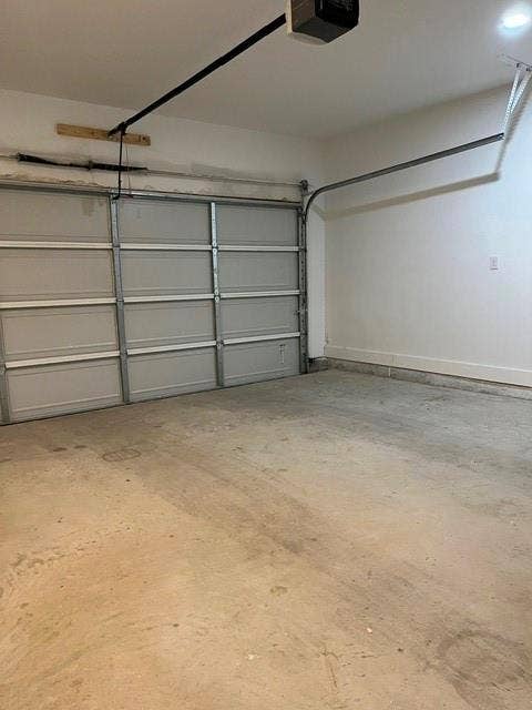 9473 Timberleaf Drive, Dallas, TX 75243 Concrete flooring with an automatic garage door opener system, white walls, and recessed lighting
