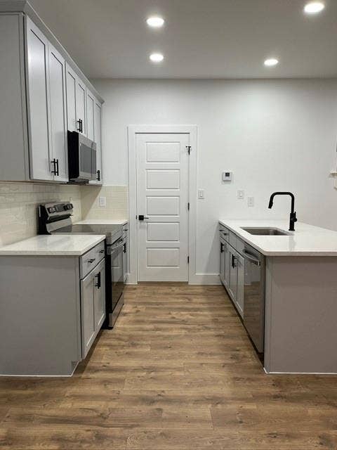 9473 Timberleaf Drive, Dallas, TX 75243 Modern kitchen featuring light gray cabinetry, white countertops, wood-finish flooring, and recessed lighting