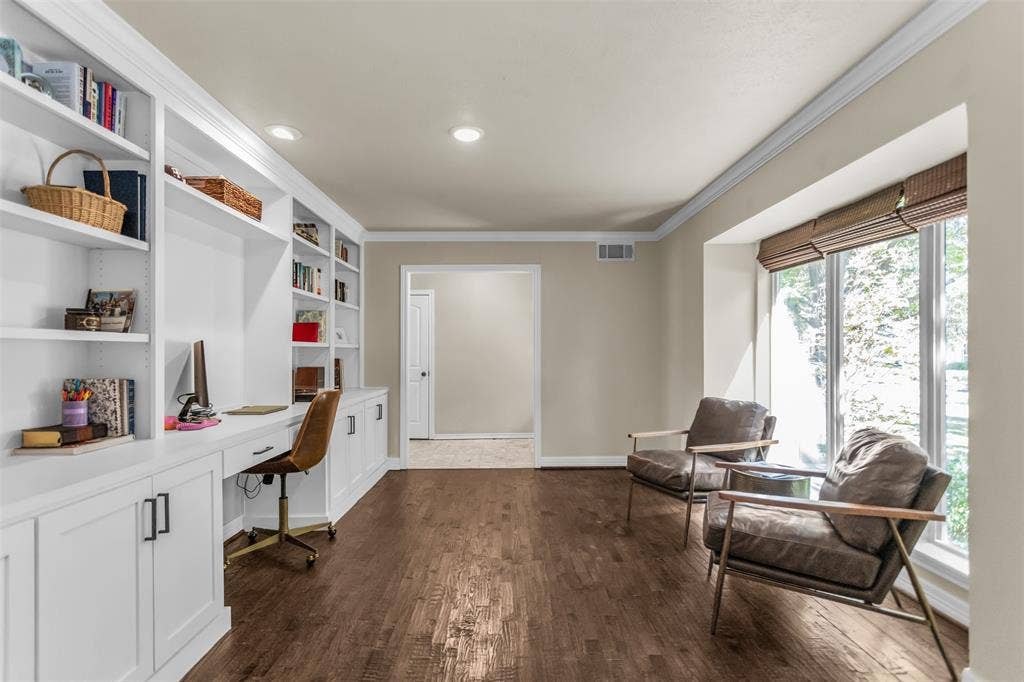 Built-in shelving and desk, recessed lighting, wood-finish flooring, crown molding, and a large window