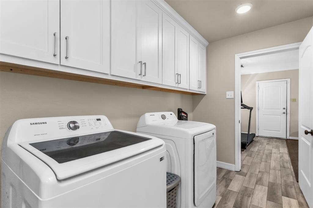 White shaker cabinetry with modern pulls, tile floor.  Full size washer dryer hookups.