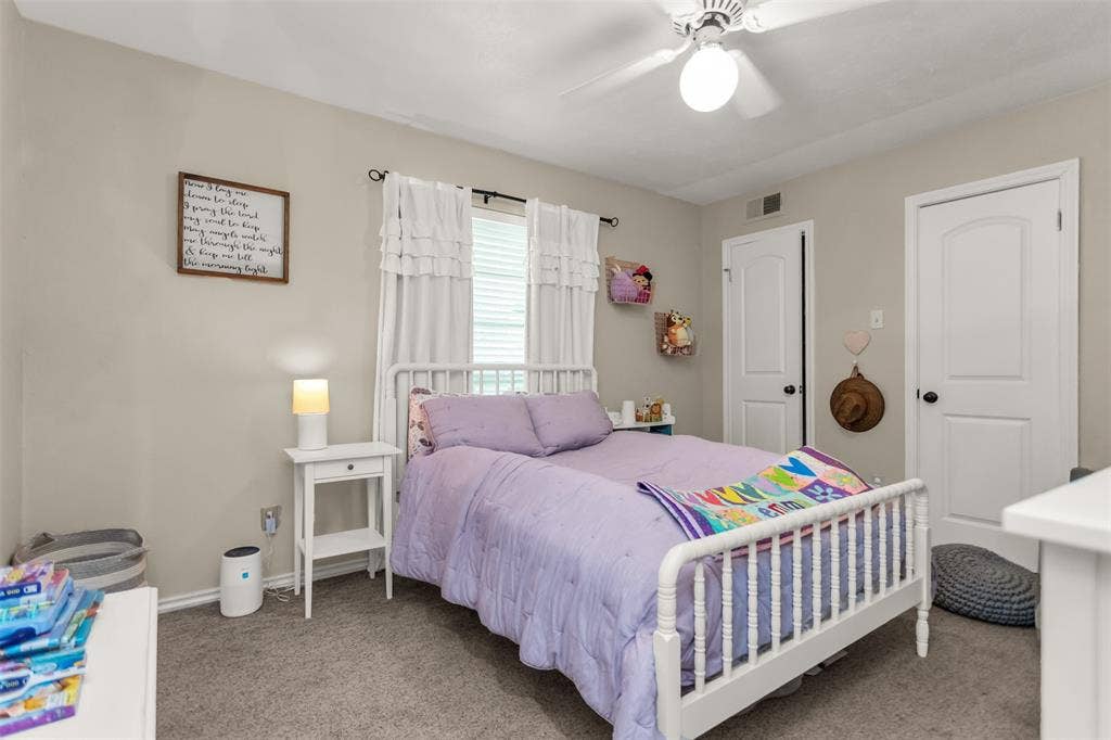 Neutral wall paint, ceiling fan with integrated lighting, window with blinds.  The two doors open to a closet.