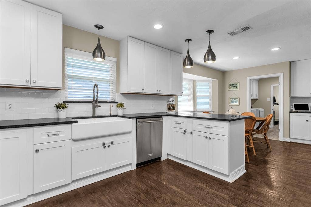 Beautiful farm sink.  SS dishwasher.  View of laundry area.