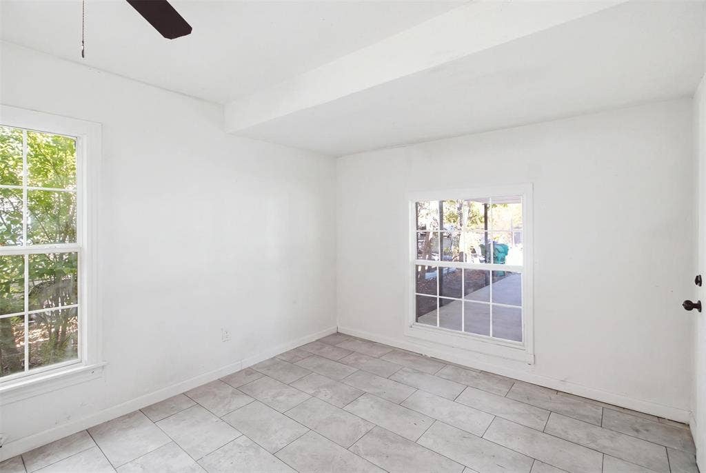 1105 Bell Drive, Greenville, TX 75401 Light tile flooring with a neutral finish, multiple windows with grid panes, and a ceiling fan