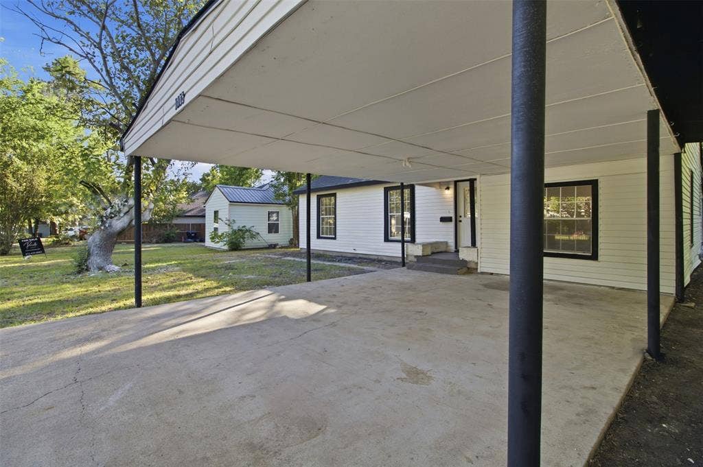1105 Bell Drive, Greenville, TX 75401 Carport with concrete pad, white siding exterior, and black trim windows