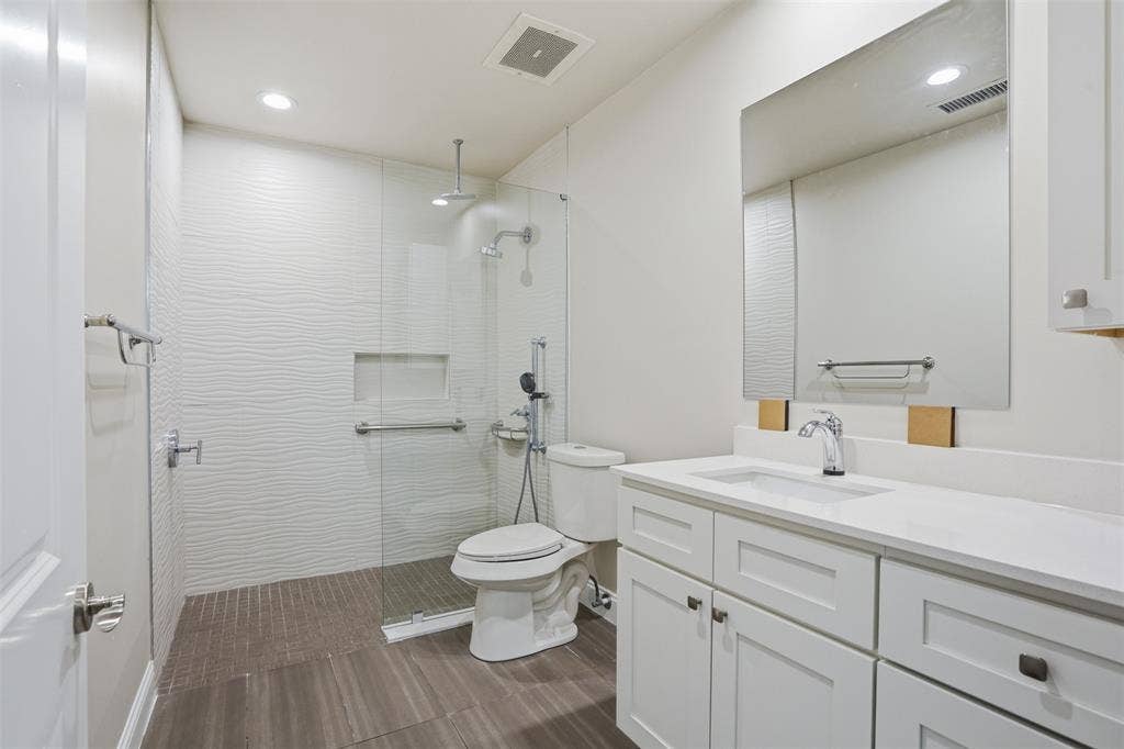 500 Throckmorton Street, #1605, Fort Worth, TX 76102 Ensuite Second Bedroom Bath features Recessed lighting illuminating a glass-enclosed shower with a textured tile surround and a built-in niche