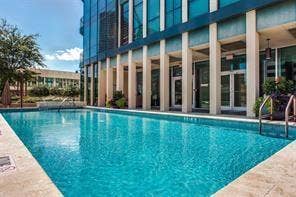 500 Throckmorton Street, #1605, Fort Worth, TX 76102 Outdoor swimming pool with concrete decking, glass-front building, and columned architectural elements