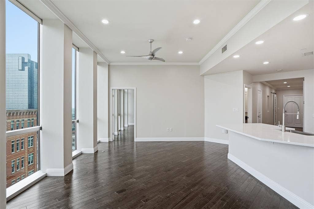 500 Throckmorton Street, #1605, Fort Worth, TX 76102 Expansive living area featuring large windows, dark wood-finish flooring, recessed lighting, and a ceiling fan