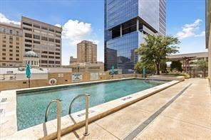 500 Throckmorton Street, #1605, Fort Worth, TX 76102 Outdoor swimming pool with concrete decking, surrounding urban architecture, and established landscaping