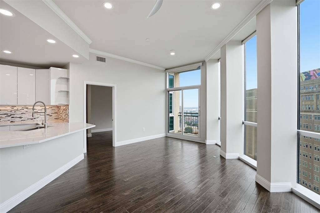 500 Throckmorton Street, #1605, Fort Worth, TX 76102 Open-concept living space with dark wood-finish flooring, recessed lighting, and expansive floor-to-ceiling windows
