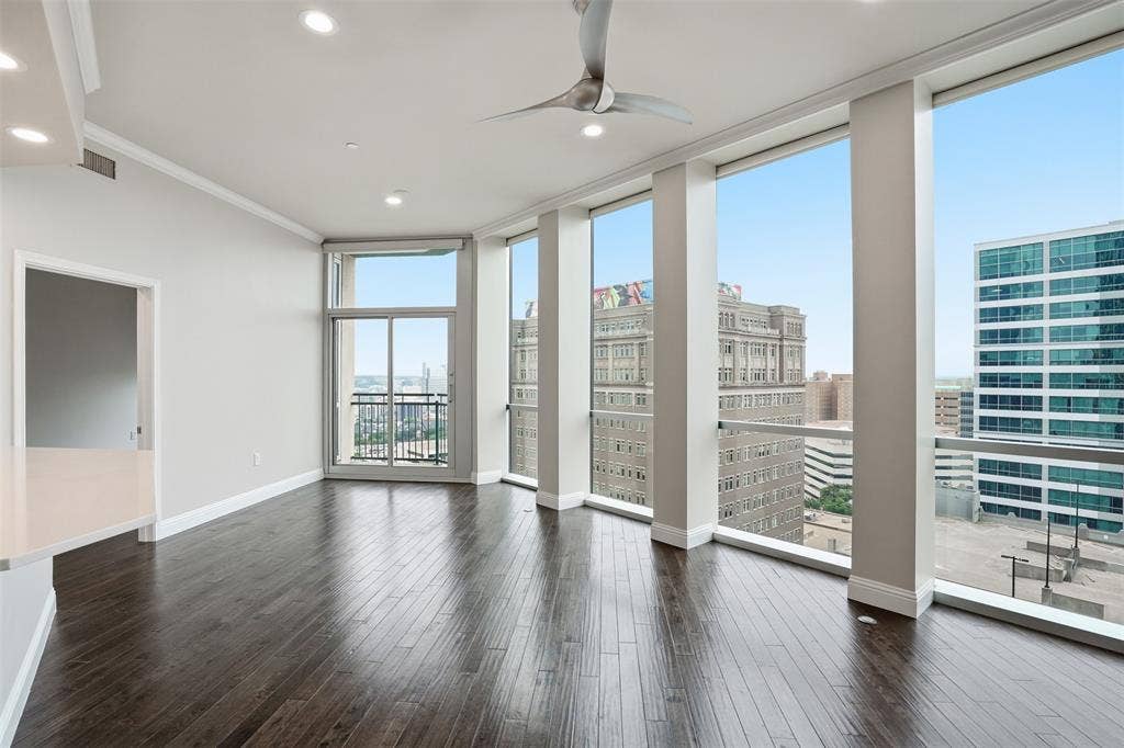 500 Throckmorton Street, #1605, Fort Worth, TX 76102 Expansive floor-to-ceiling windows, dark wood-finish flooring, recessed lighting, crown molding, and a modern ceiling fan