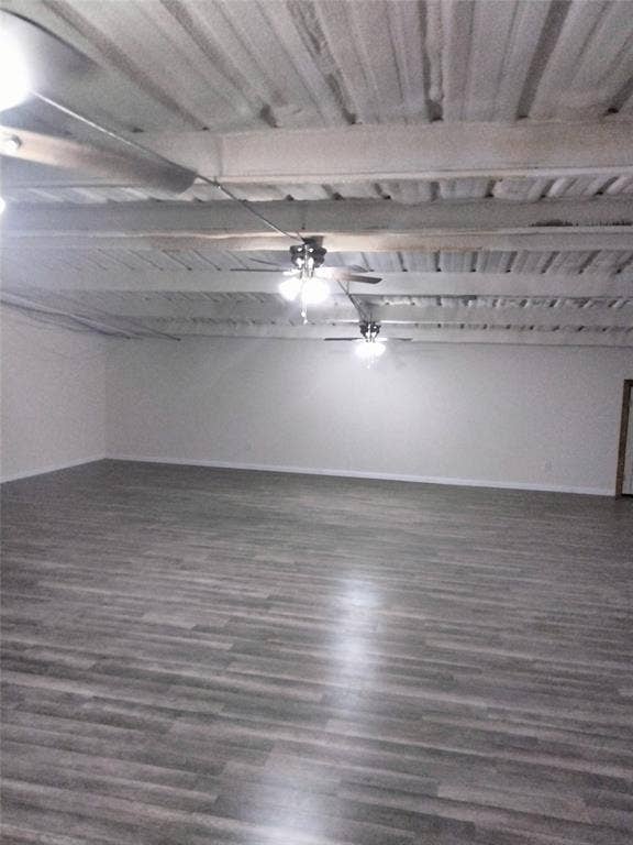 10424 County Road 1099, Princeton, TX 75407 Expansive open-concept room featuring wood-finish flooring, white walls, exposed beam ceiling, and multiple ceiling fans with light fixtures