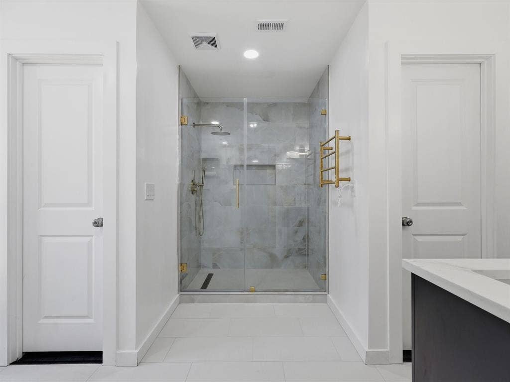 2500 Teakwood Lane, Plano, TX 75075 Glass-enclosed shower with gold-finish hardware, recessed lighting, and a rainfall showerhead