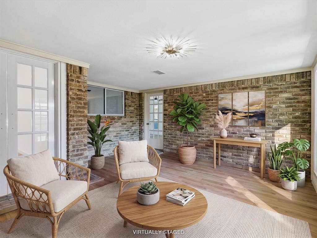 2500 Teakwood Lane, Plano, TX 75075 Brick accent wall, wood-finish flooring, white crown molding, recessed lighting, and white French doors