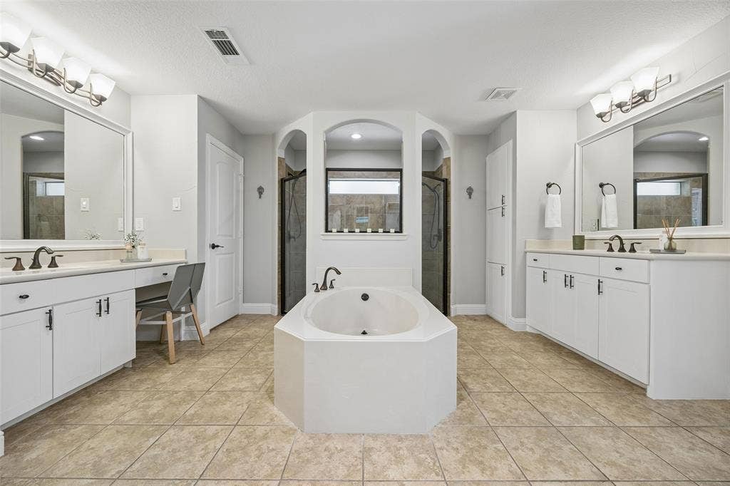 Split sinks and dual showerheads highlight the primary bath
