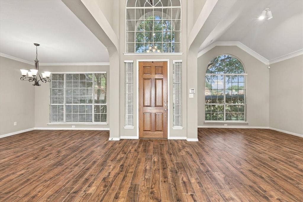2412 Clearwood Lane, Flower Mound, TX 75028 PREPARE TO BE IMPRESSED! Soaring ceilings, an extraordinary oversized arched window, elegant wood-look tile flooring, and graceful architectural details create a dramatic entrance flooded with natural light. Formal living/study and dining spaces frame this stunning grand foyer.