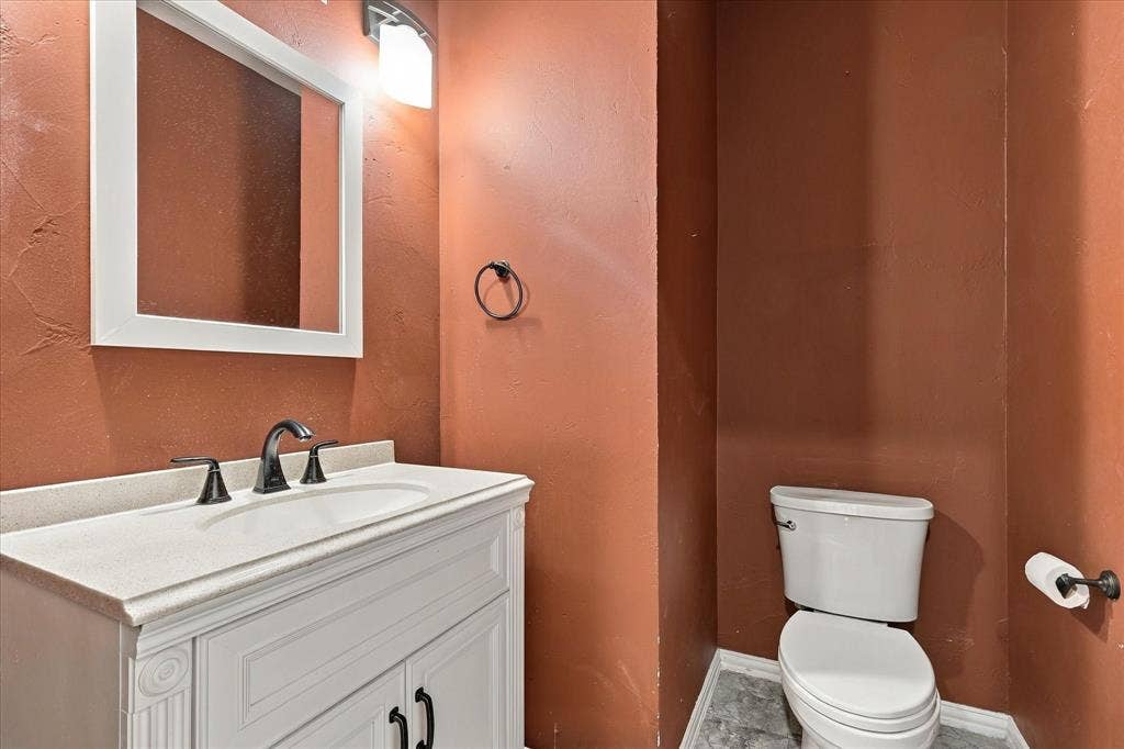 2412 Clearwood Lane, Flower Mound, TX 75028 A TOUCH OF BOLD SOPHISTICATION! Warm, dramatic wall tones, a beautifully detailed vanity, contrasting white countertop, and stylish dark fixtures bring distinctive personality to this conveniently located powder room.