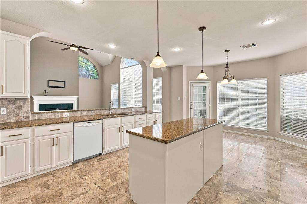 2412 Clearwood Lane, Flower Mound, TX 75028 DESIGNED FOR GATHERING IN STYLE! This spacious kitchen combines generous counter space, beautiful freshly painted cabinetry with new hardware, an impressive center island, and a sun-filled breakfast area, all overlooking the home's spectacular living room and fireplace.