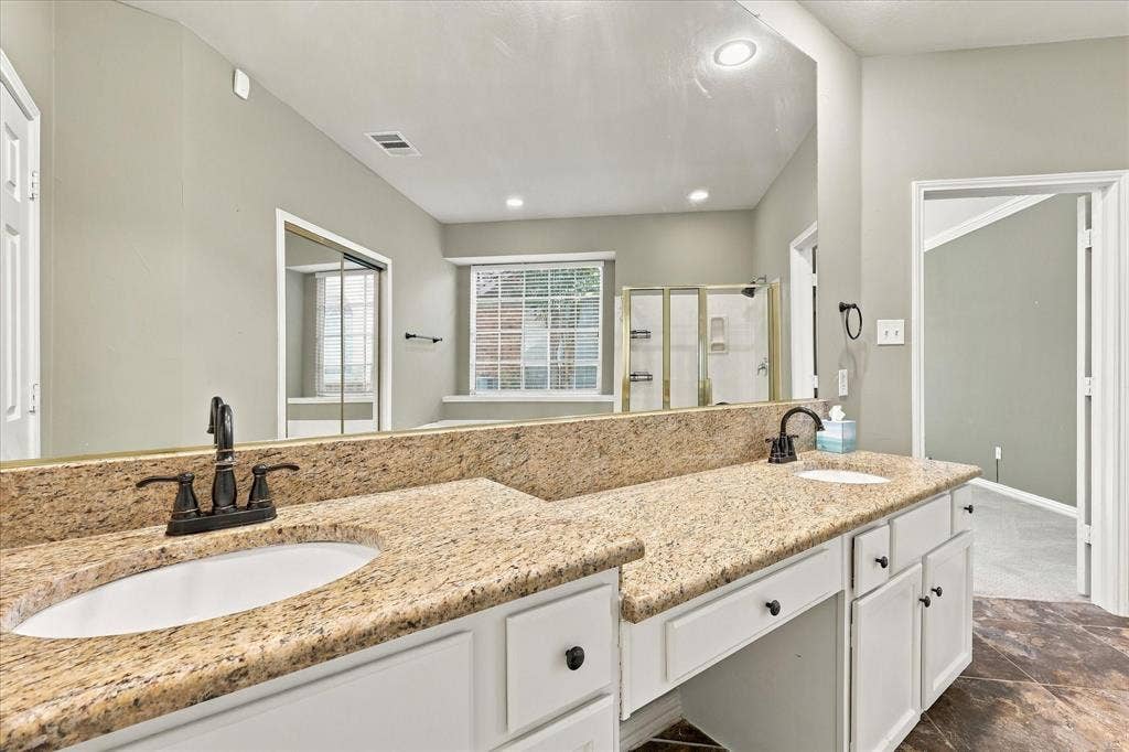 2412 Clearwood Lane, Flower Mound, TX 75028 A TOUCH OF EVERYDAY INDULGENCE! Double sinks, beautiful granite countertops, stylish dark fixtures, and an oversized mirror offer generous personal space and classic sophistication.