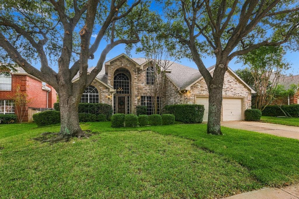 2412 Clearwood Lane, Flower Mound, TX 75028 A GRAND ENTRANCE TO EXCEPTIONAL LIVING! Framed by majestic mature trees and beautifully established landscaping, this striking two-story brick residence commands attention with its timeless architecture, dramatic arched windows, and sophisticated curb appeal. A captivating first impression that perfectly sets the stage for the elegance and grandeur found within!