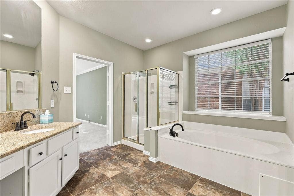2412 Clearwood Lane, Flower Mound, TX 75028 RELAXATION NEVER LOOKED SO INVITING! A beautiful soaking tub, separate glass-enclosed shower, frsh paint and sun-filled window create a serene escape, complemented by elegant granite countertops and timeless finishes