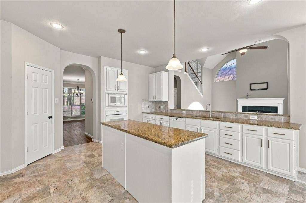 2412 Clearwood Lane, Flower Mound, TX 75028 WHERE STYLE MEETS EVERYDAY LIVING! Gorgeous granite countertops, crisp white cabinetry, elegant pendant lighting, and an expansive center island create an inviting kitchen that flows effortlessly into the dramatic two-story living room.