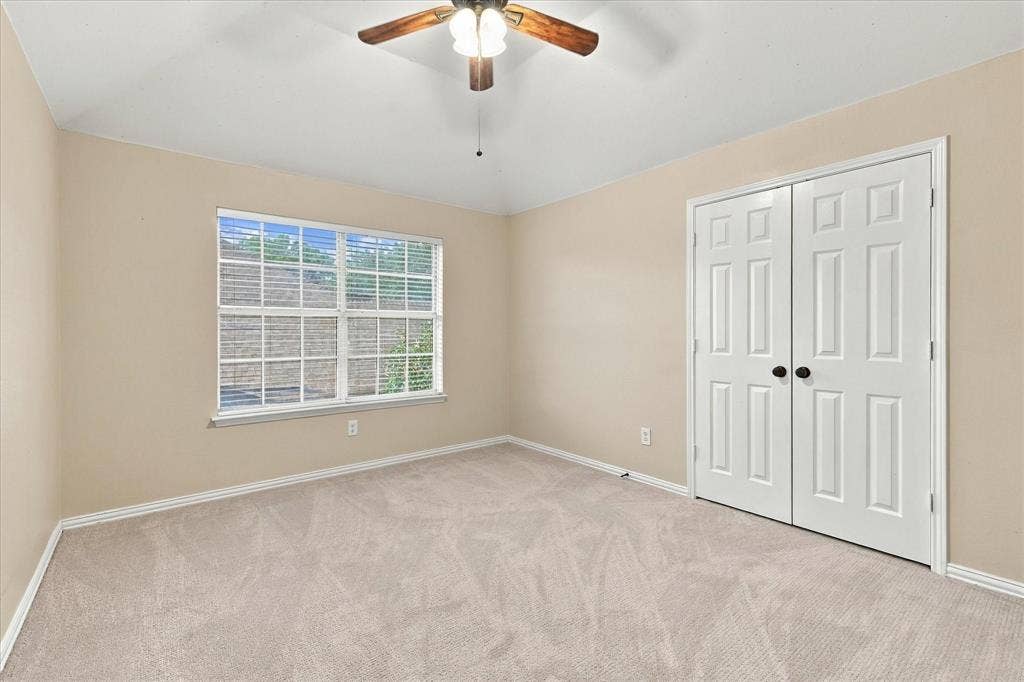 2412 Clearwood Lane, Flower Mound, TX 75028 COMFORT, CHARM, AND NATURAL LIGHT! This spacious bedroom features plush new carpeting, a beautiful window overlooking the outdoors, a ceiling fan, and a generous double-door closet.