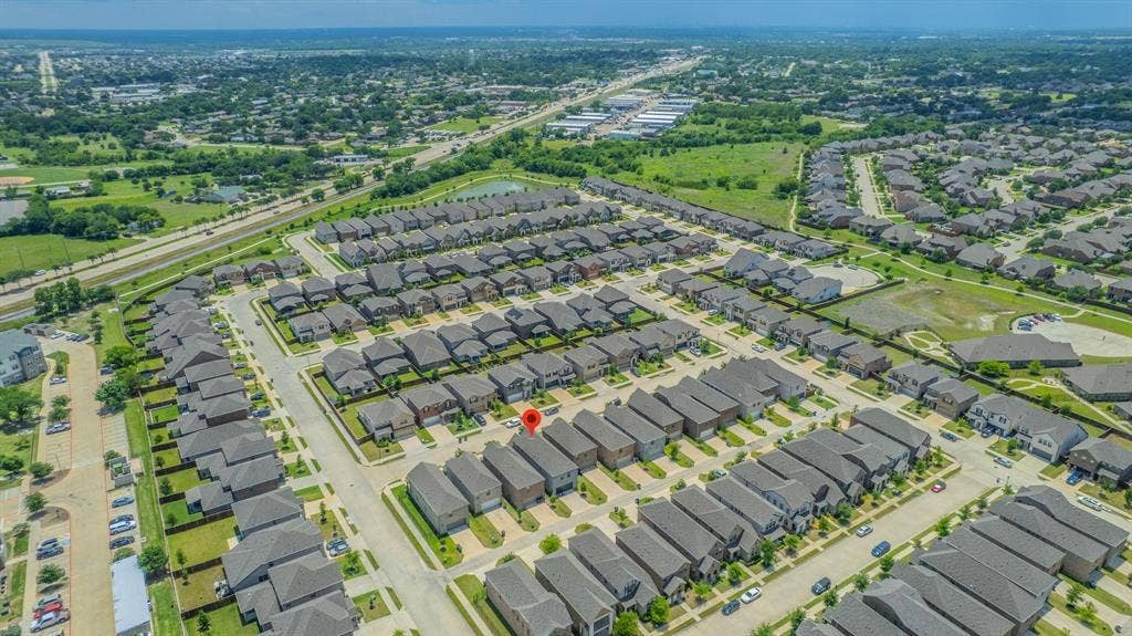 4129 Bullwhip Creek Lane, Sachse, TX 75048 Aerial perspective of a developed residential community with uniform rooflines and landscaped properties