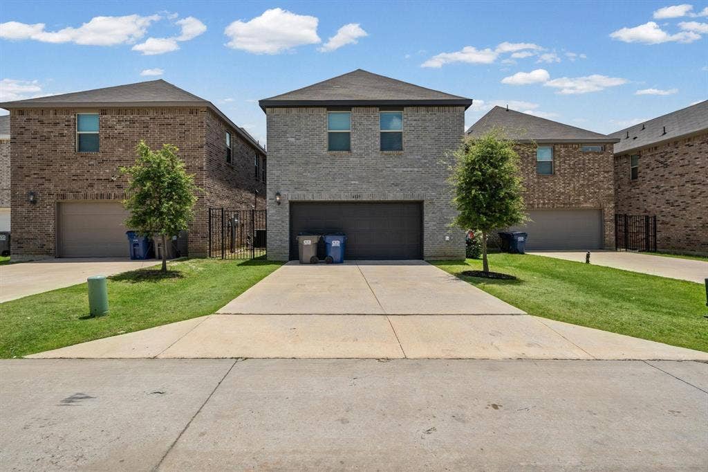 4129 Bullwhip Creek Lane, Sachse, TX 75048 Two-story brick exterior with an attached garage, featuring a concrete driveway and a manicured lawn