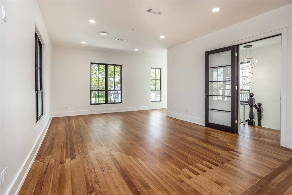 Interior space featuring wood-finish flooring, recessed lighting, and expansive windows with black frames
