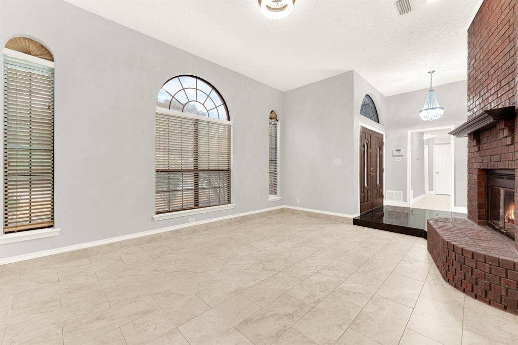 Sweeping tile floors reflect ambient light, effortlessly connecting the entry foyer to the main living area. You can easily envision welcoming guests through double doors for lively weekend dinner parties