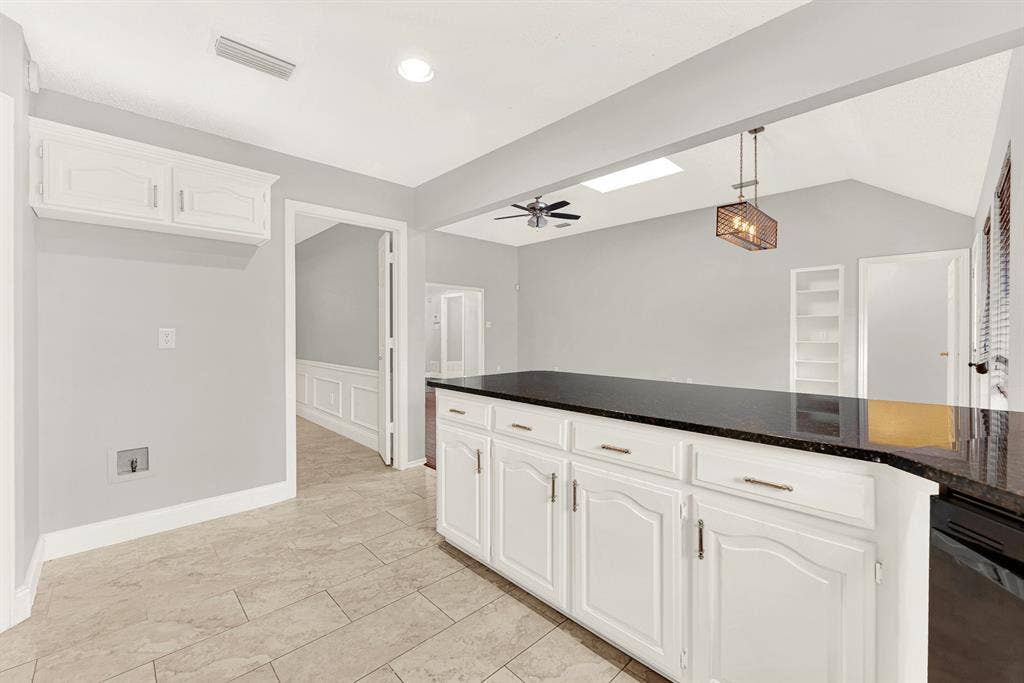 An expansive breakfast bar seamlessly bridges the cooking zone with adjacent living areas under high ceilings. Visualize family chatting over casual weeknight meals while prep work happens effortlessly nearby