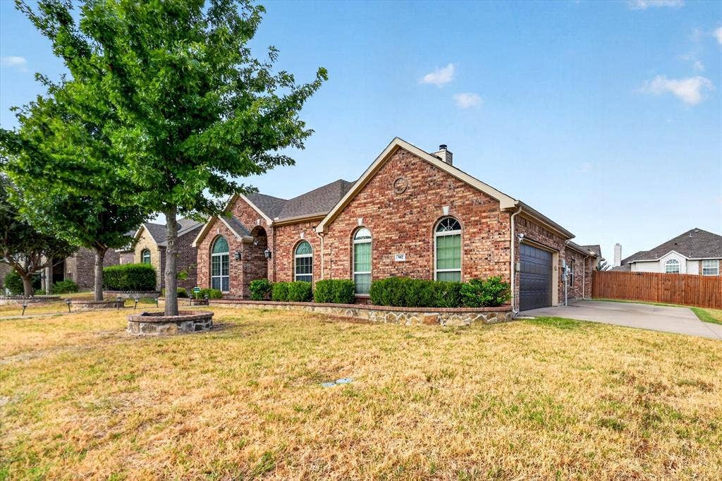 902 Nikki Drive, Cedar Hill, TX 75104 Brick exterior with arched windows, an attached garage, and a concrete driveway
