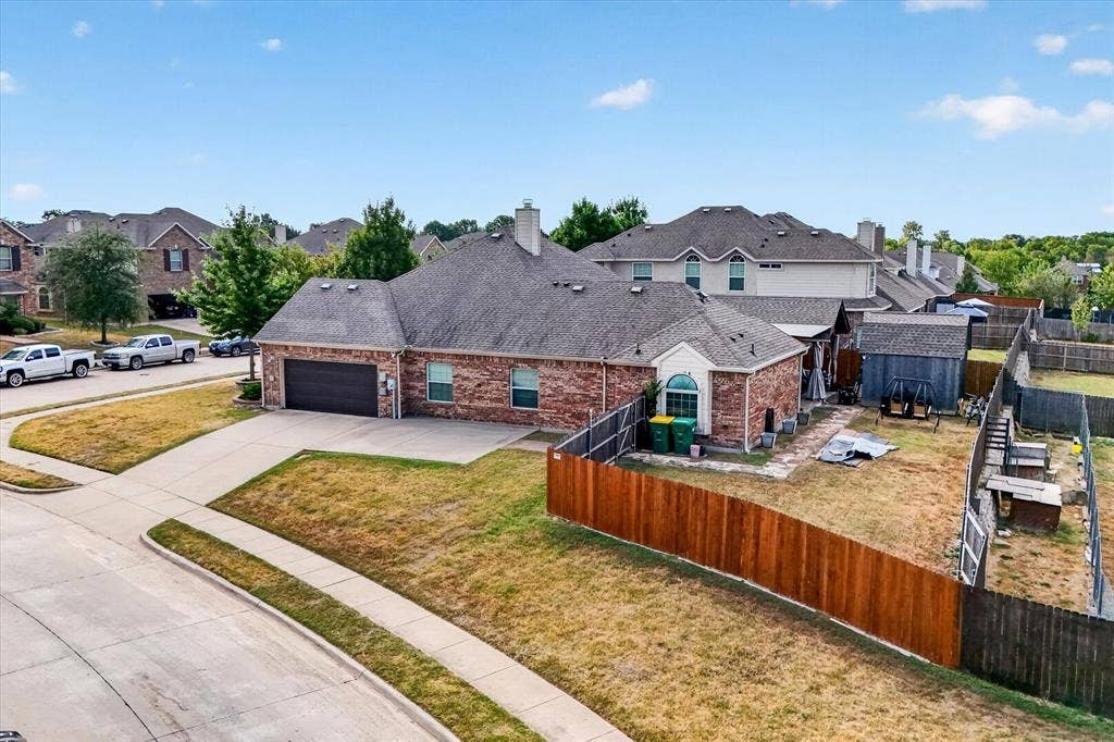 902 Nikki Drive, Cedar Hill, TX 75104 Brick exterior with arched window, attached two-car garage, and fenced backyard