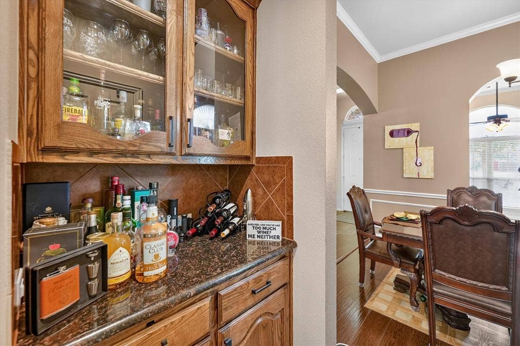 902 Nikki Drive, Cedar Hill, TX 75104 Built-in cabinetry with glass-front uppers, tile backsplash, and dark countertop