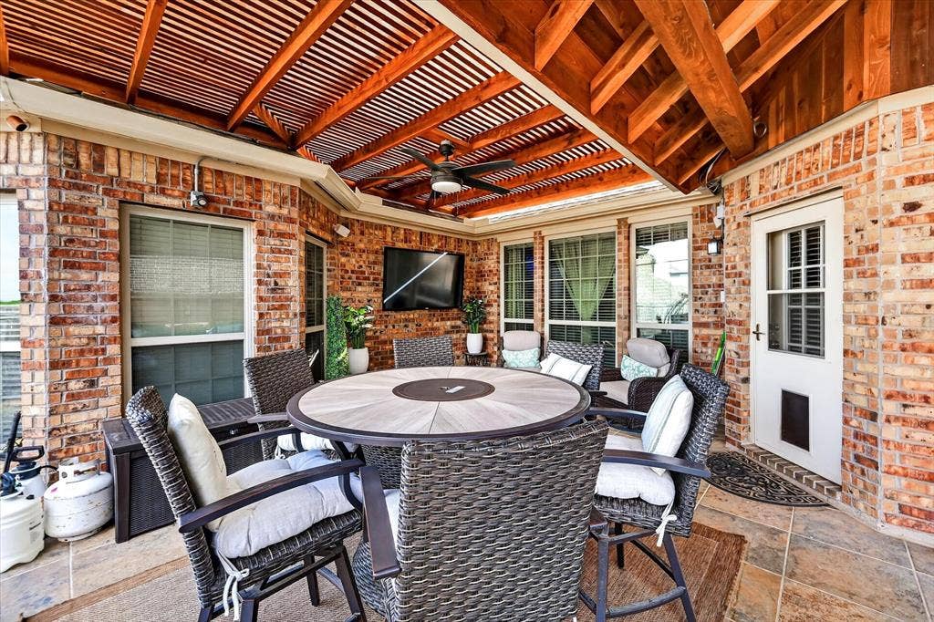 902 Nikki Drive, Cedar Hill, TX 75104 Brick exterior featuring a wood slat ceiling, exposed wood beams, ceiling fan, and tiled flooring