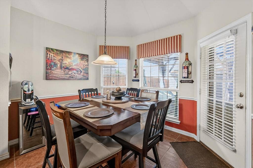 902 Nikki Drive, Cedar Hill, TX 75104 Dining area featuring a central chandelier, multiple windows with horizontal blinds, and a paneled white door