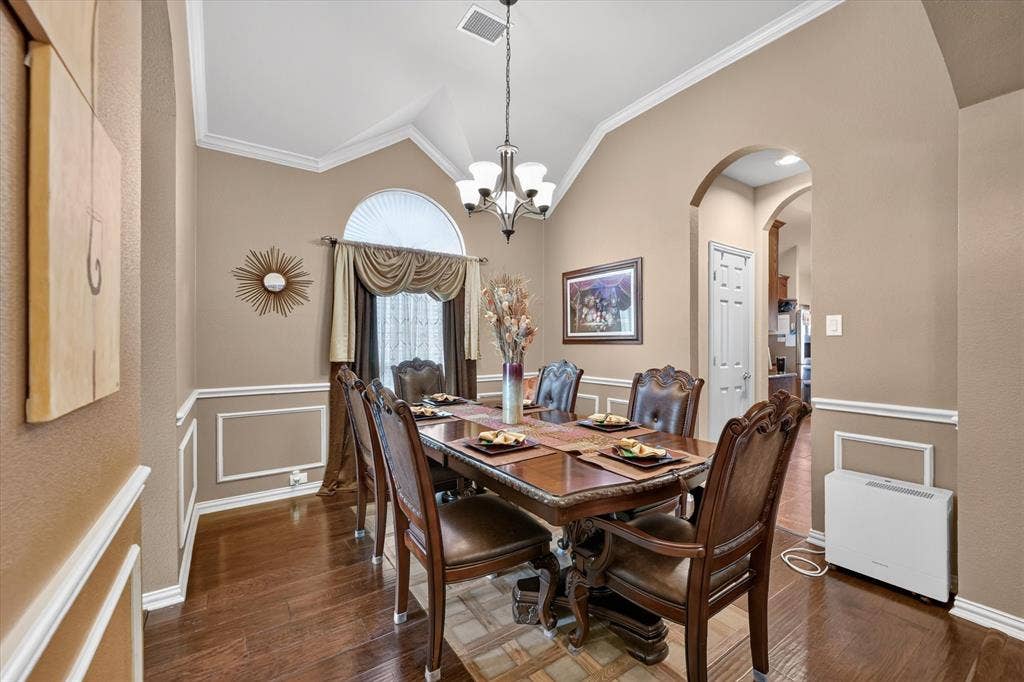 902 Nikki Drive, Cedar Hill, TX 75104 Wood-finish flooring, vaulted ceiling, crown molding, arched entryways, and picture frame wainscoting