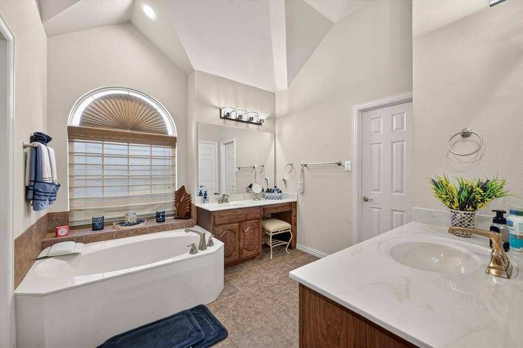 902 Nikki Drive, Cedar Hill, TX 75104 Soaking tub with tiled surround, arched window, and custom blinds