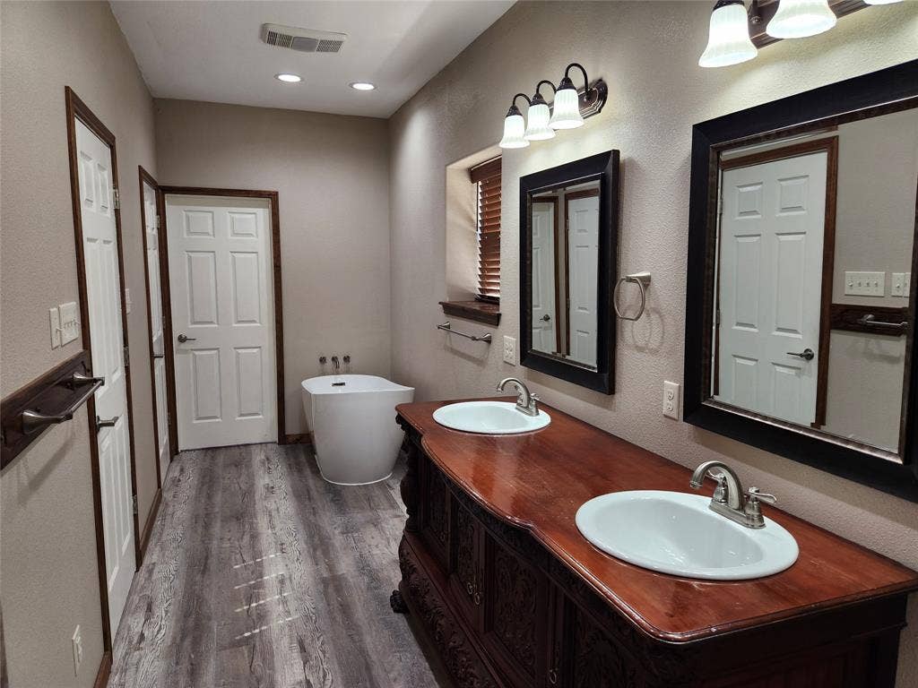 Primary bathroom with soaking tub and custom dual vanity.