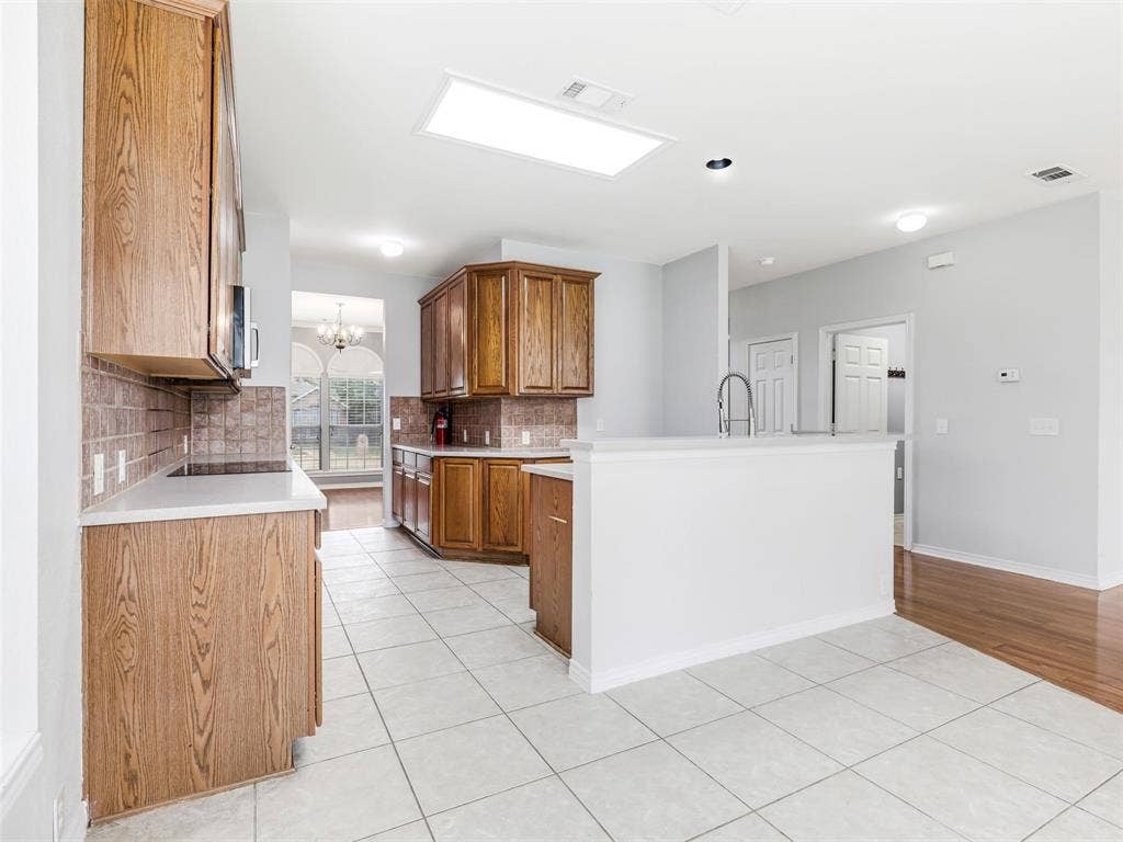 7419 Ravenhill Drive, Frisco, TX 75035 Kitchen featuring wood cabinetry, white countertops, tile backsplash, stainless steel sink, and recessed lighting