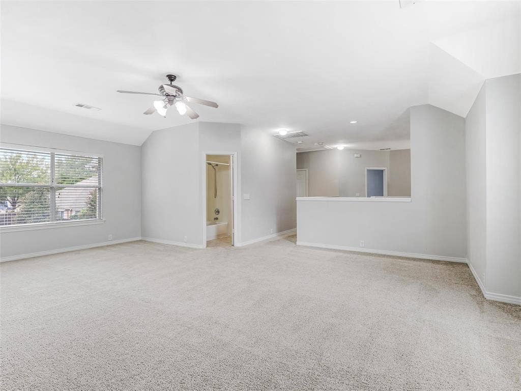 7419 Ravenhill Drive, Frisco, TX 75035 Expansive carpeted room featuring vaulted ceilings, a ceiling fan, and a large window with blinds