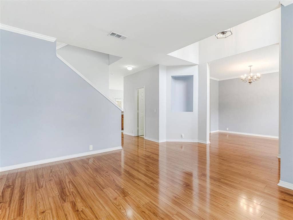 7419 Ravenhill Drive, Frisco, TX 75035 Wood-finish flooring throughout, crown molding, recessed lighting, built-in wall niche, and an overhead chandelier