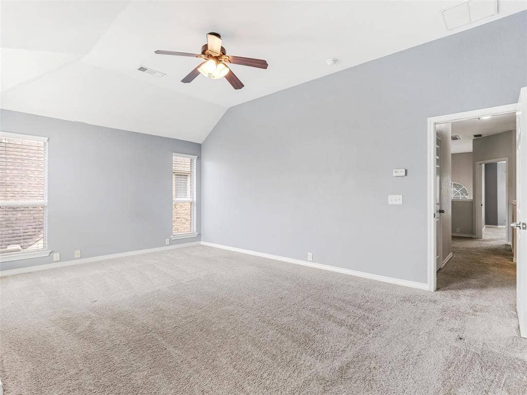 7419 Ravenhill Drive, Frisco, TX 75035 Vaulted ceiling with an attached ceiling fan, dual windows, and light gray wall paint