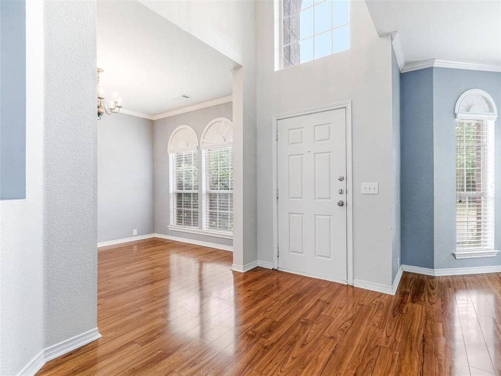 7419 Ravenhill Drive, Frisco, TX 75035 Vaulted entryway with a transom window, wood-finish flooring, and white trim