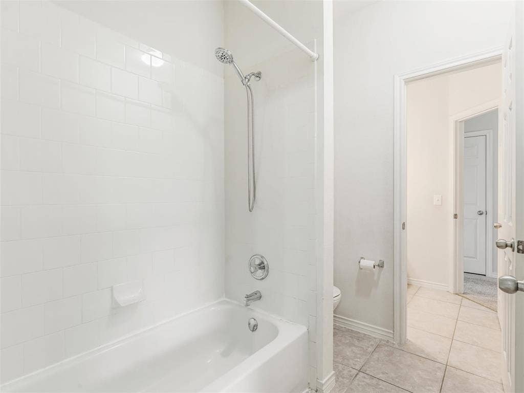 7419 Ravenhill Drive, Frisco, TX 75035 White subway tile shower surround with a built-in tub and chrome fixtures