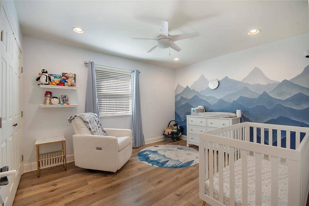 4074 Cedar Bayou Drive, Dallas, TX 75244 Wood-finish flooring with a white dresser, crib, and a wall mural